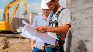 Duas pessoas lendo um papel mostrando a diferença entre construtora e empreiteira